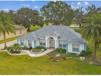 Beautiful single-story home with a well-manicured lawn, blue trim, and mature landscaping at 5407 County Road 125, Wildwood, FL 34785