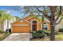 Charming one-story home featuring a two-car garage, well-maintained landscaping, and inviting curb appeal at 1029 Orange Cosmos Blvd, Davenport, FL 33837