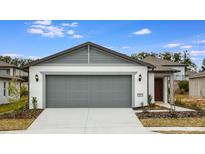 Inviting exterior of a single-story home with a gray garage door and landscaping at 5414 Sw 85Th Avenue Rd, Ocala, FL 34481