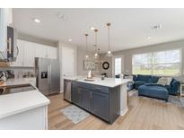 Modern kitchen featuring a gray island, stainless steel appliances, and an open layout at 1624 Pelican Dr, Davenport, FL 33896