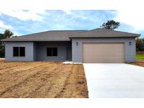 Newly constructed home with gray siding and a two-car garage at 13898 Sw 32Nd Ter, Ocala, FL 34473