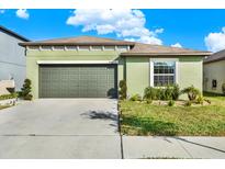 Charming single-story home featuring a well-kept lawn, an attached garage and neutral stucco exterior at 4310 Trotters Way, Lakeland, FL 33801