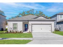 Charming single-story home with a two-car garage, well-manicured lawn, and a pop of color with a vibrant purple front door at 13489 Leaping Water Way, Astatula, FL 34705