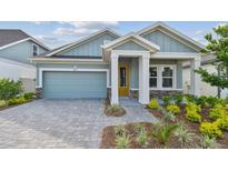 Charming single-story home with a well-manicured lawn and a stylish blue exterior and yellow door at 6063 Sacred Oak Ave, Mount Dora, FL 32757