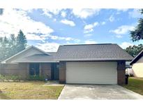 Brick house with a two-car garage and well-maintained lawn at 341 N Fork Dr, Lakeland, FL 33809