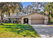 House exterior with a brown garage door and well-maintained lawn at 509 E Lakeshore Dr, Ocoee, FL 34761