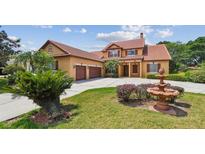 Elegant two-story home showcasing a well-manicured lawn and charming architectural details at 2024 Capri Ln, Mount Dora, FL 32757