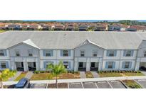 Aerial view of townhouses with gray and white exterior, and parking at 7614 Oak Spring Ln, Davenport, FL 33837