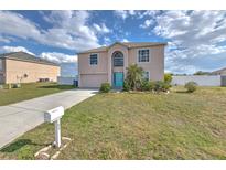 Two-story home with a well-manicured lawn, bright blue front door, and attached two-car garage at 169 Vista View Ave, Eagle Lake, FL 33839