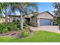New home exterior with landscaping, two-car garage, and palm trees at 368 Toldedo Rd, Davenport, FL 33837
