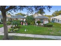Charming single-story home with well-manicured lawn, festive holiday decorations, and mature landscaping at 1694 Town Park Dr, Port Orange, FL 32129