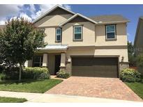 Inviting two-story home features a brick driveway, a two car garage, and manicured landscaping at 745 Marsh Reed Dr, Winter Garden, FL 34787