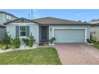 One-story home with gray siding, brick driveway and landscaped lawn at 3052 Cassidy Ln, Haines City, FL 33844