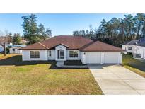 Newly built home with 2-car garage, and well-manicured lawn at 9825 Sw 46Th Ct, Ocala, FL 34476