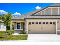 Tan house with gray roof, double garage door, and walkway at 3179 Seville St, Lake Alfred, FL 33850