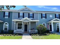 Charming townhome with a manicured lawn, classic architectural details, and a welcoming front porch at 525 Waterside Pointe Dr, Groveland, FL 34736