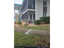 Low-rise building with manicured lawn, rock garden, and covered balconies with screened enclosures at 1600 W Lake Parker Dr # A6, Lakeland, FL 33805
