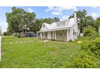Charming home featuring a white exterior, metal roof, and a cozy front porch at 415 Avenue K Ne, Winter Haven, FL 33881