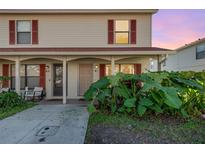 Tan two-story condo building with red-trimmed windows and lush landscaping at 980 Canal View Blvd # G1, Port Orange, FL 32129