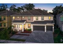 Two-story home with a three car garage and landscaping at 2541 Shanti Dr, Kissimmee, FL 34746