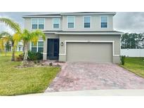 Two-story house with a two-car garage and a brick paver driveway at 1403 Eucalyptus Way, Davenport, FL 33837