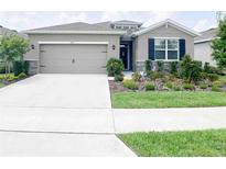 Single-story house with a two-car garage and landscaped front yard at 5450 Sunshine Dr, Wildwood, FL 34785