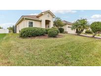 Stunning single-story home featuring a red tile roof, arched entryway and a lush, well-manicured front yard at 4026 Navigator Way, Kissimmee, FL 34746