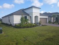 Single-story home with gray roof, white walls, and landscaping at 621 San Augusto Dr, Poinciana, FL 34759