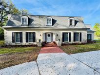Charming two-story home with classic brick exterior, dormer windows, and professionally landscaped front yard at 165 Leslie Ln, Lake Mary, FL 32746