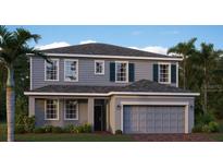 Two-story house with gray siding, a two-car garage, and landscaping at 274 Puma Loop, Groveland, FL 34736