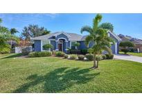 Single-story home with a landscaped lawn, palm trees, and a two-car garage at 4545 Mandolin Blvd, Winter Haven, FL 33884