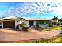 Charming single-story home featuring a metal roof, meticulous landscaping, and a spacious driveway at 225 Temple Cir, Eustis, FL 32726