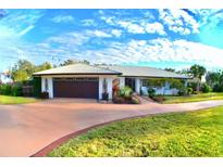 Beautiful ranch home with a metal roof, landscaping, and a long driveway at 225 Temple Cir, Eustis, FL 32726