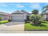 One-story house with gray siding, two-car garage, and landscaped lawn at 3782 Hampton Hills Dr, Lakeland, FL 33810