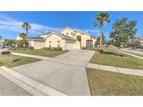 Charming two-story home featuring a well-maintained yard, palm trees, and a spacious driveway at 108 Emeraldview Ave, Davenport, FL 33897