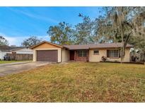 Brick ranch house with attached garage and well-maintained lawn at 5157 Black Birch Trl, Mulberry, FL 33860