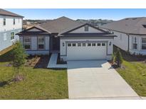Charming single-story home with a manicured lawn, two car garage, and a concrete driveway at 1258 Lakeridge Way, Lake Alfred, FL 33850