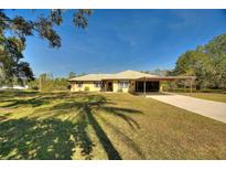 Single-story home with a covered carport and a spacious yard at 4680 Poinciana Dr, Indian Lake Estates, FL 33855