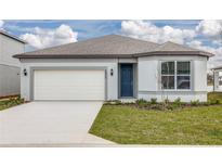 Charming single-story home with a blue front door, attached garage, and well-manicured lawn at 6805 Sw 90Th Loop, Ocala, FL 34476