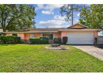 Charming single-story home with a well-manicured lawn and a two-car attached garage at 683 Anderson Dr, Deltona, FL 32725