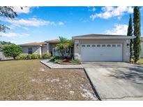 Single-story home with a two-car garage and landscaped yard at 1371 Laurel Glen Dr, Bartow, FL 33830