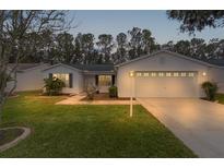 Inviting home exterior featuring a two-car garage and well-manicured lawn at 1309 Ballesteros Dr, The Villages, FL 32162