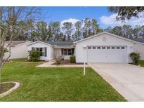 Single-story house with a two-car garage and well-maintained lawn at 1309 Ballesteros Dr, The Villages, FL 32162