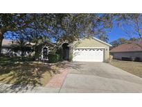 Single-story house with attached garage and landscaped yard at 30132 Pga Dr, Sorrento, FL 32776