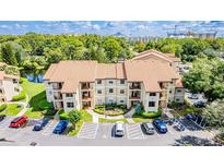 Aerial view of a two-story condo building with ample parking at 3036 Parkway Blvd # 206, Kissimmee, FL 34747