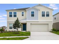 Two-story house with neutral siding, teal door and attached garage at 2204 Canyon Oak Dr, Davenport, FL 33837