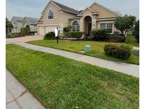 Two-story house with landscaped lawn and attached garage at 113 Walton Heath Dr, Orlando, FL 32828