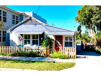 Charming cottage with a picket fence and colorful details at 311 N Baker St, Mount Dora, FL 32757