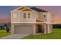 Two-story house with gray siding, orange accents, and a two-car garage at 3468 Dahlia Dr, Lake Hamilton, FL 33851