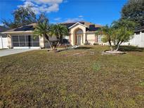 House exterior featuring solar panels, landscaping, and a two-car garage at 619 Parakeet Ct, Kissimmee, FL 34759
